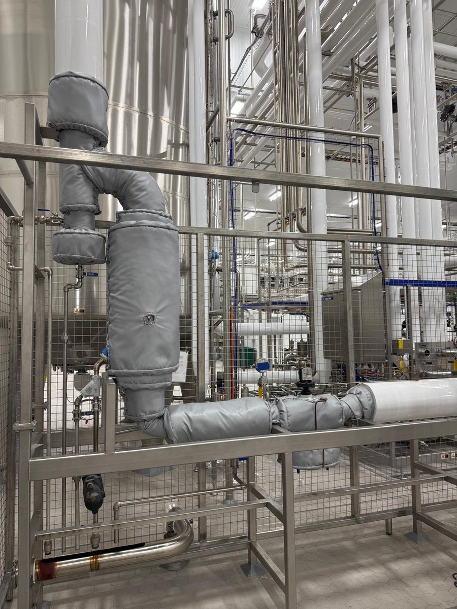 Removable insulation blankets fitted to process piping, elbows, and valves in a food and beverage facility